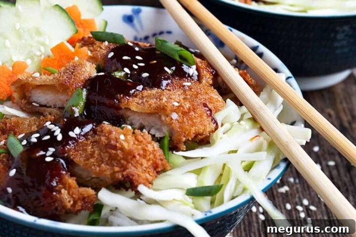 Crispy pork katsu rice bowls with chopsticks, showcasing the meal.