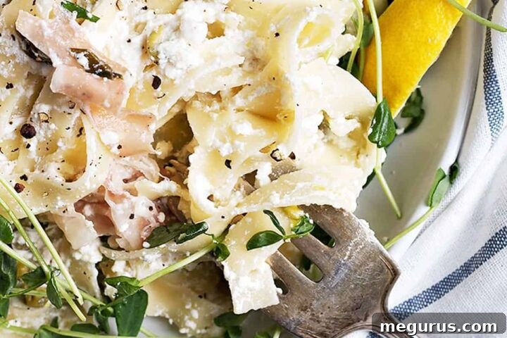 lemon ricotta pasta with prosciutto - a serving in a white bowl garnished with pea shoots