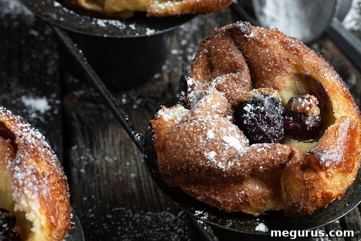 Delicious sugar crusted blackberry popovers arranged on a cooling rack, ready to be enjoyed.