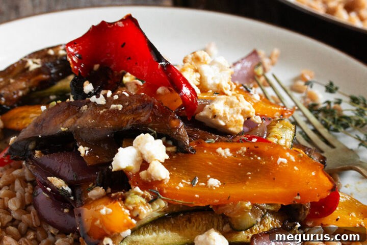Roasted vegetable farro salad on a plate with a fork, ready to be enjoyed.