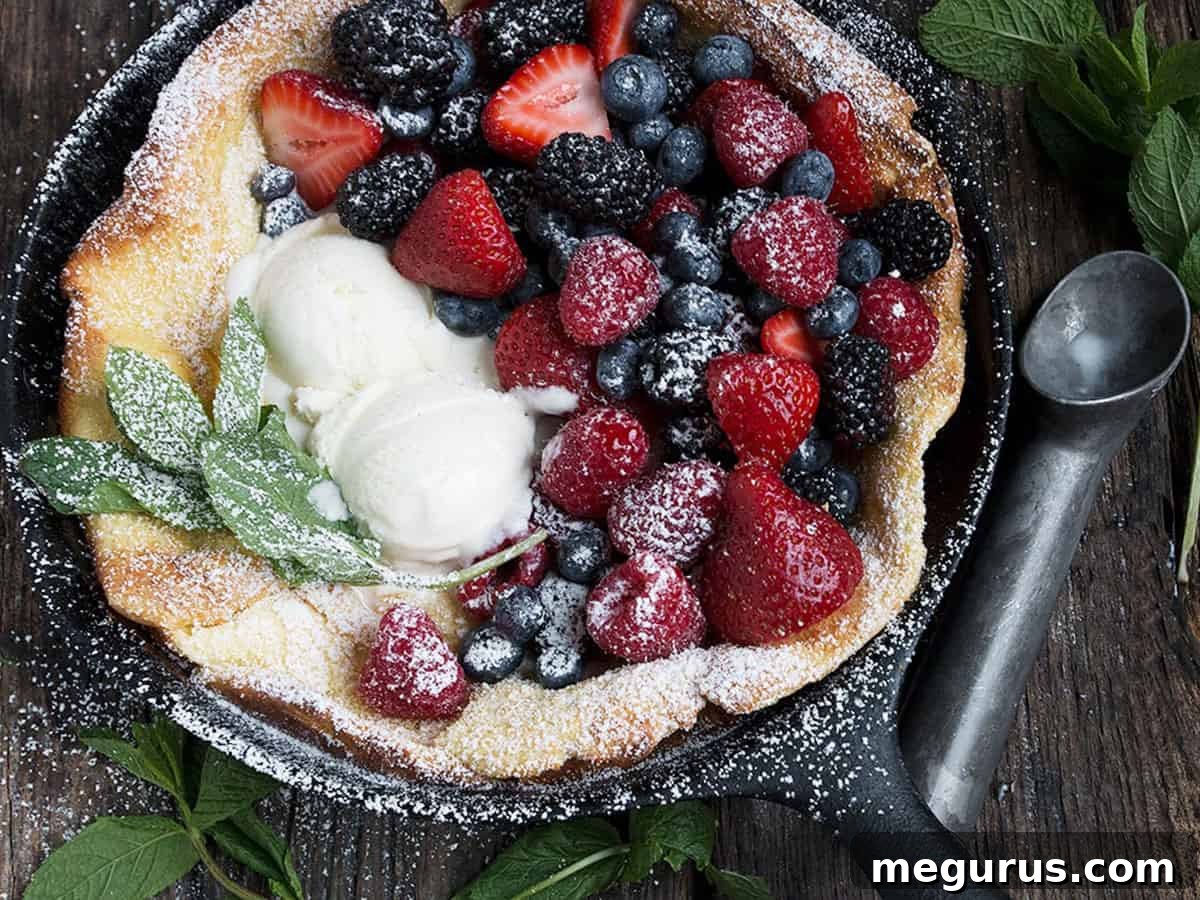 Fresh fruit Dutch Baby pancake in a cast iron skillet, brimming with colorful berries