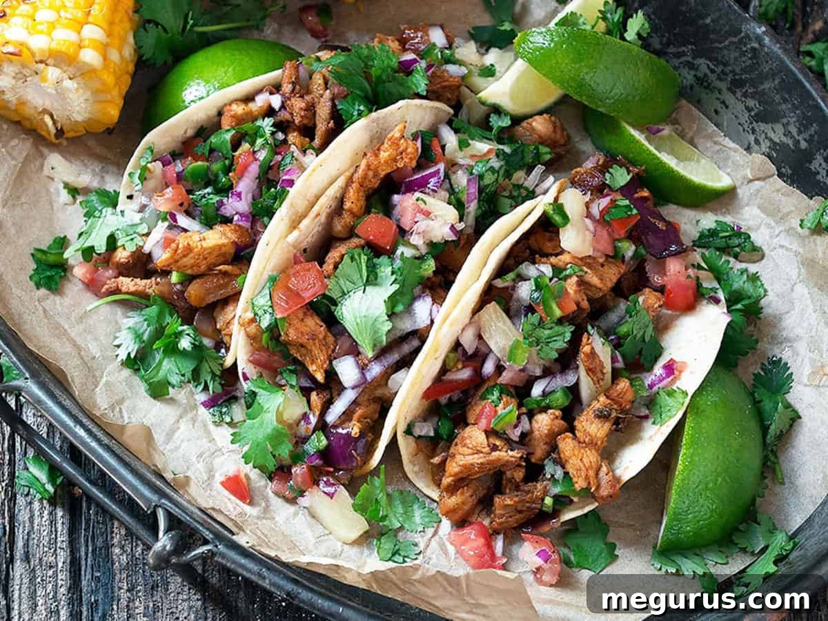 Delicious al pastor tacos on a platter with fresh lime slices, ready to be served.