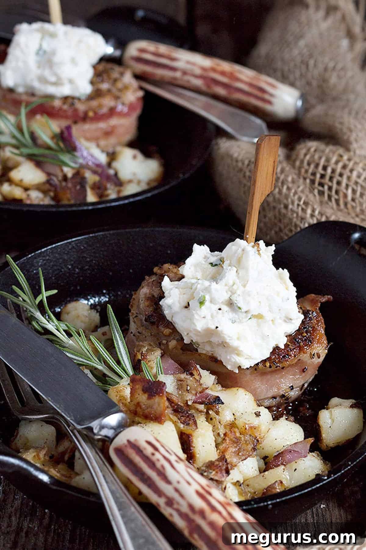 Close-up of bacon wrapped pork medallions in a small skillet, glistening and perfectly cooked, with a dollop of feta topping.