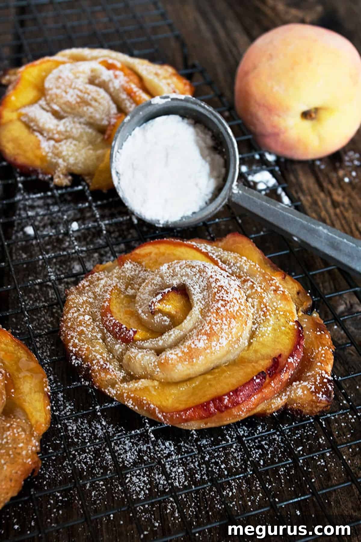 Baked rose-shaped peach puff pastries on a cooling rack