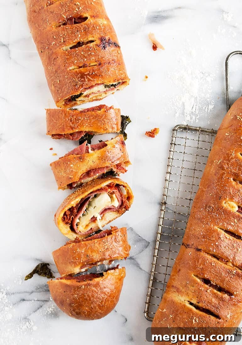 Close-up of perfectly baked, golden-brown classic stromboli slices, revealing the melted cheese, meats, and basil.