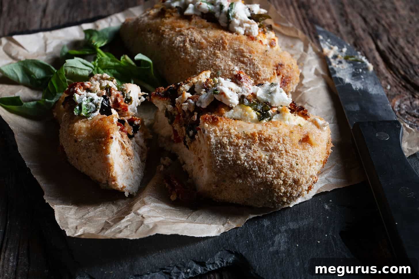 Goat cheese stuffed chicken on cutting board, showcasing the rich filling.