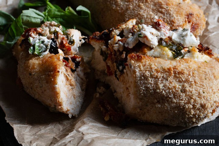 Goat cheese stuffed chicken on cutting board.