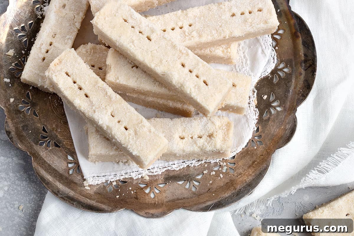 Classic Scottish shortbread cookies arranged beautifully on an antique silver platter, showcasing their golden-brown edges and delicate appearance.