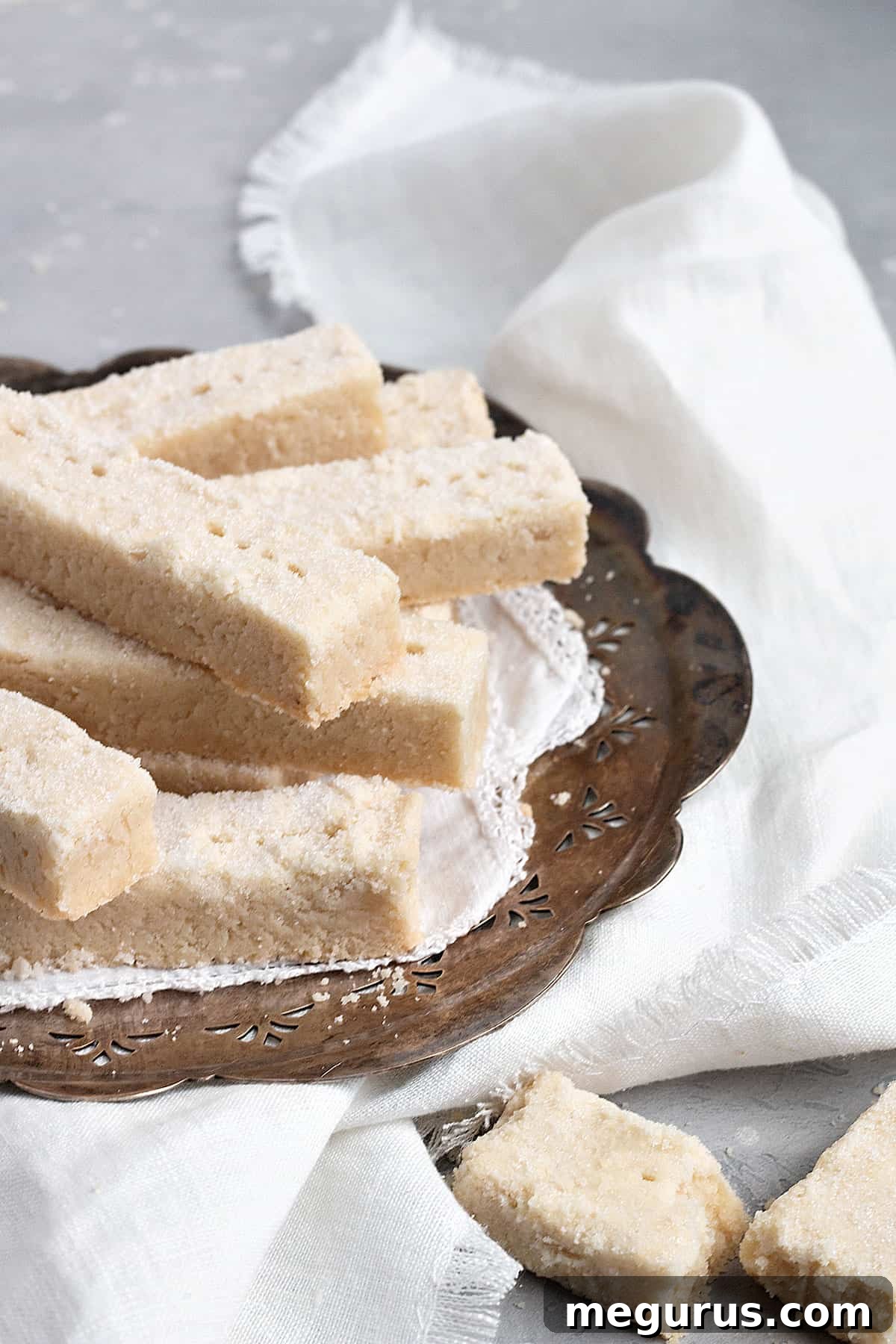 A close-up shot of crispy Scottish shortbread fingers on an elegant silver platter, ready to be served, highlighting their golden hue and inviting texture.