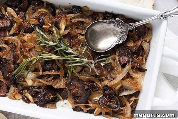 Warm Goat Cheese Fig Dip in a white dish with a spoon, ready to be served