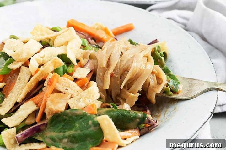A beautifully presented Buddha bowl in a white bowl with a fork, highlighting the fresh ingredients and vibrant colors.