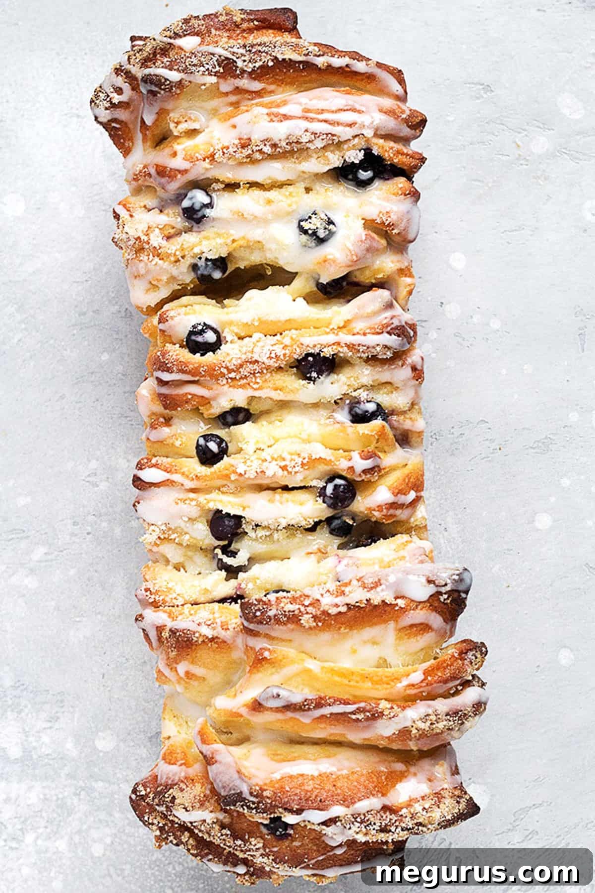 Lemon Blueberry Pull Apart Bread drizzled with lemon glaze, served on a baking sheet
