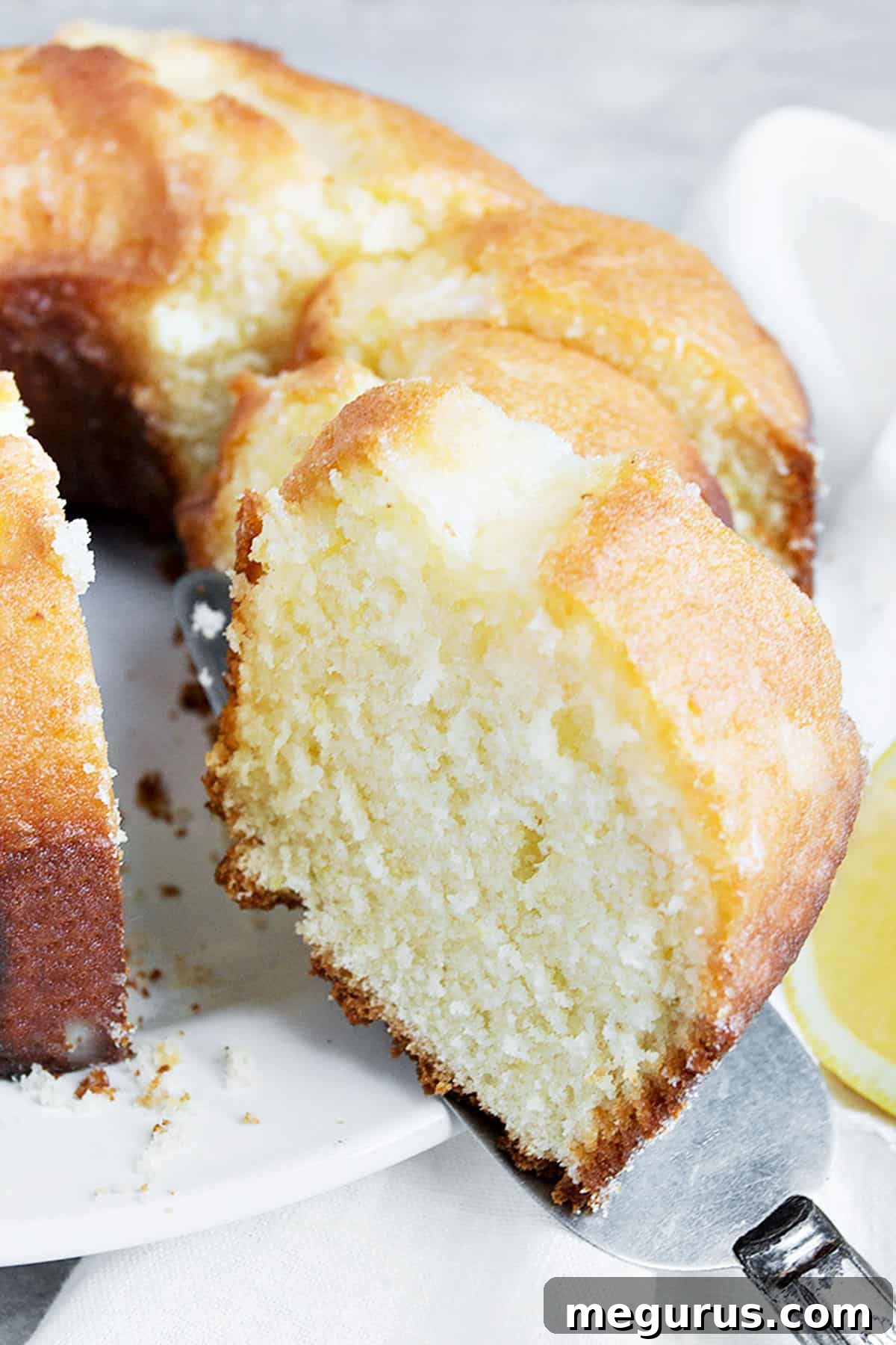 Close-up of a lemon tube cake sliced, showing the moist interior and glazed top.