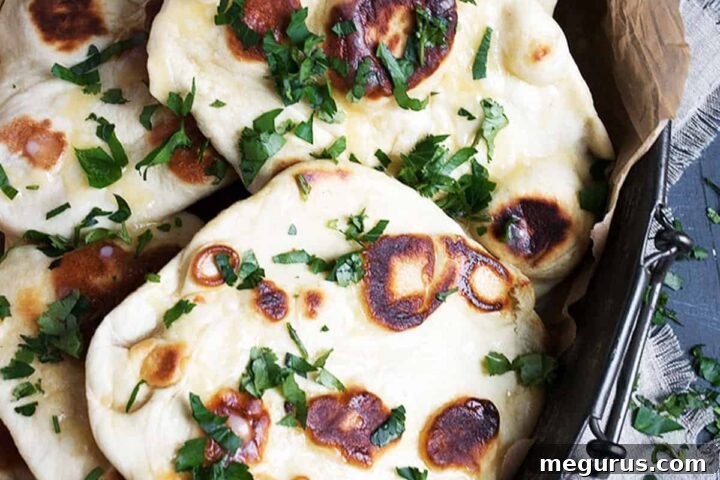 Delicious garlic naan bread on a metal platter, ready to be served.