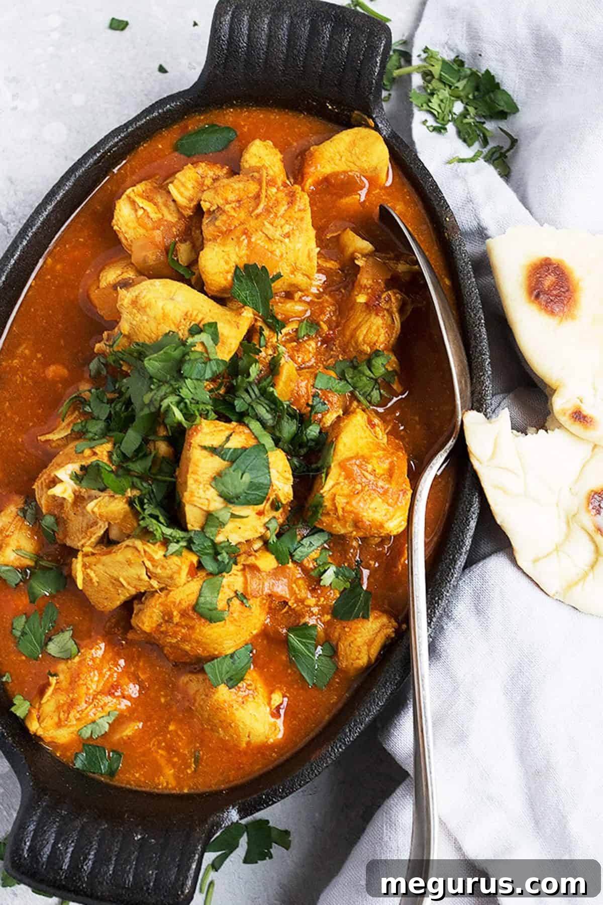 Close-up of bubbling Easy Chicken Vindaloo in a pot, garnished with fresh cilantro, ready to be served