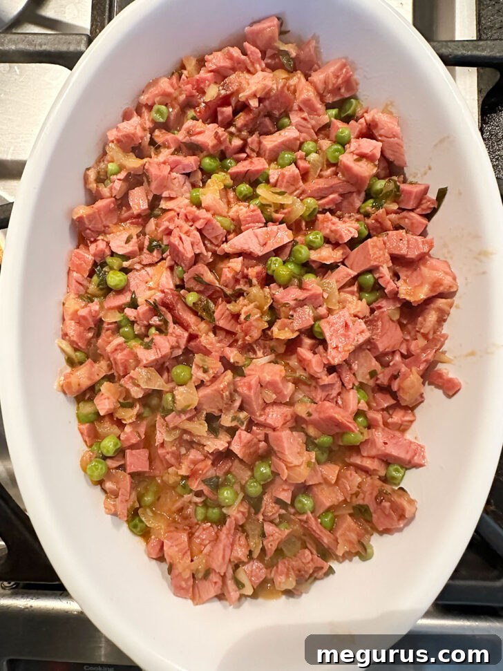 The rich corned beef mixture neatly transferred into a small, oven-safe baking dish, ready for the potato topping.