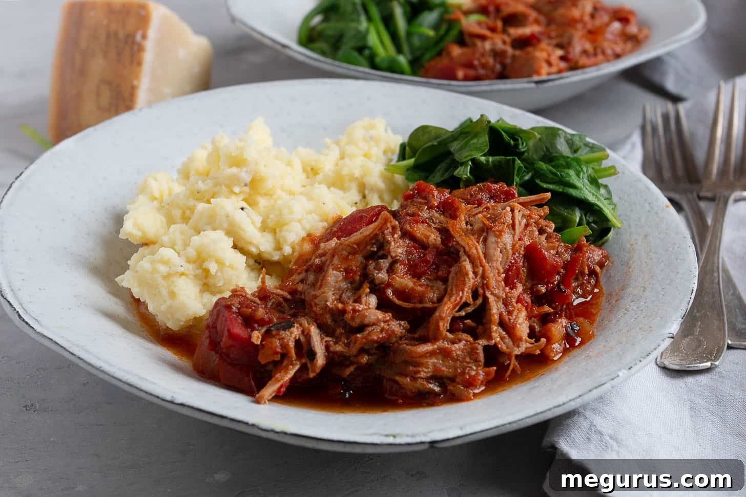 Pork Arrabbiata served on a plate with creamy mashed potatoes and vibrant green spinach