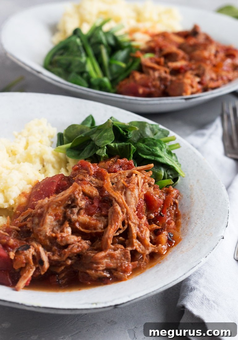 Close-up of Pork all'Arrabbiata simmering in a Dutch oven, showing the rich tomato sauce and tender pork chunks