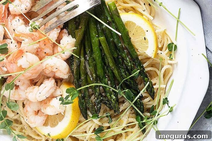 lemon pasta with shrimp and asparagus on white platter