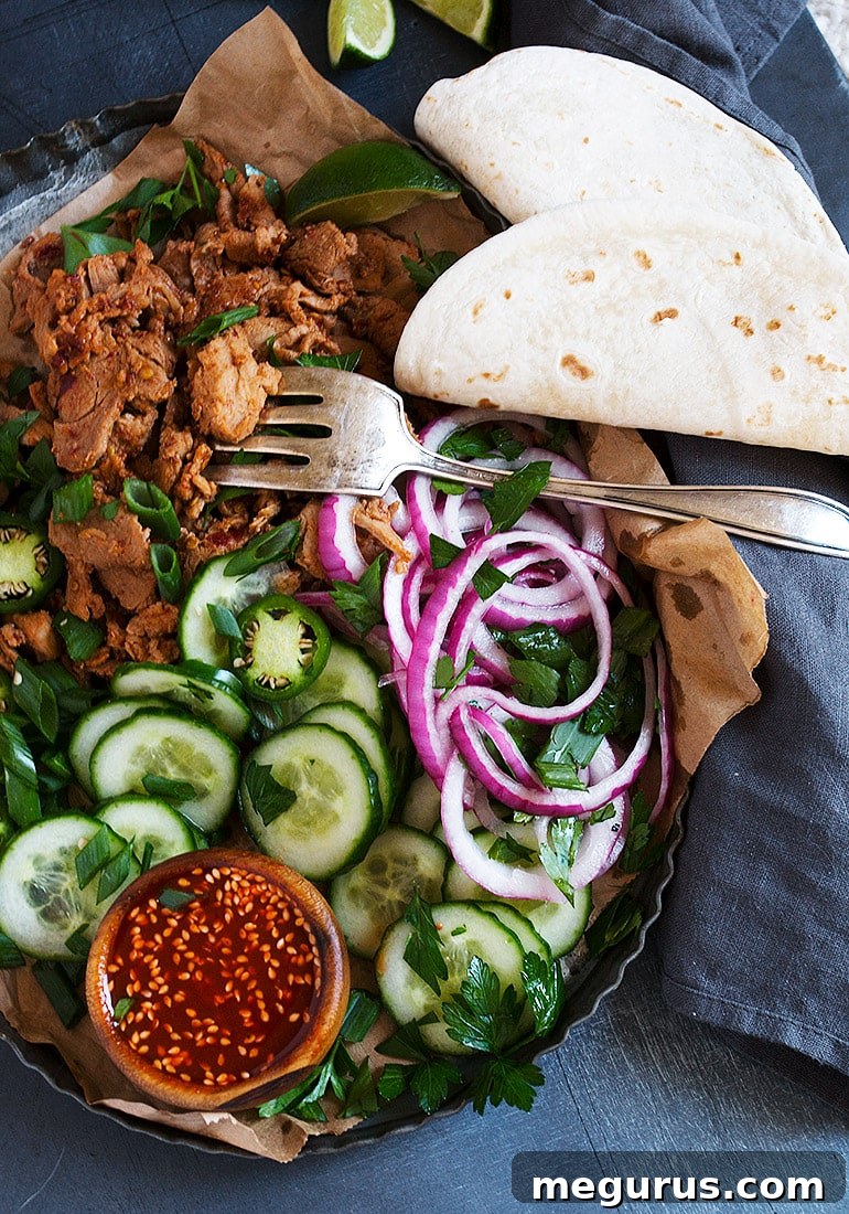 Close-up of a spicy Korean pork taco in hand, showcasing the vibrant fillings