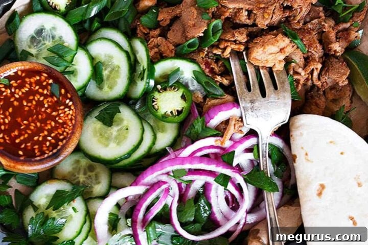 A platter of fully assembled spicy Korean pork tacos with various toppings