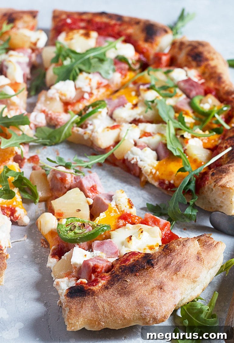 Close-up of three cheese Hawaiian pizza being sliced with a pizza cutter, highlighting the perfectly melted cheese and toppings.