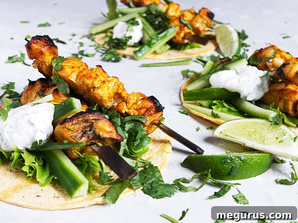 Delicious chicken tikka tacos served on a wooden board with fresh cilantro and lime wedges