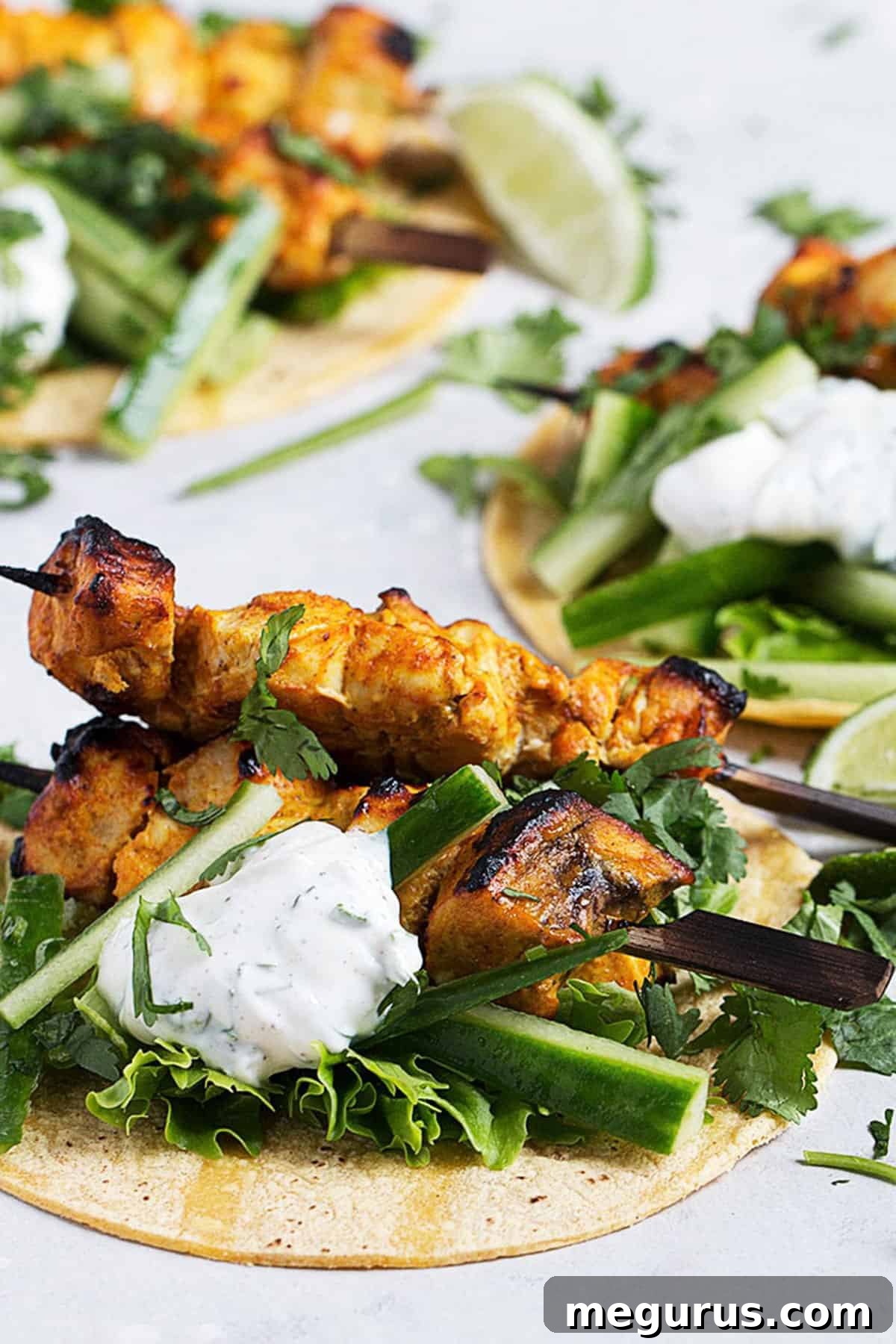Close-up of a chicken tikka taco with fresh garnishes and yogurt sauce