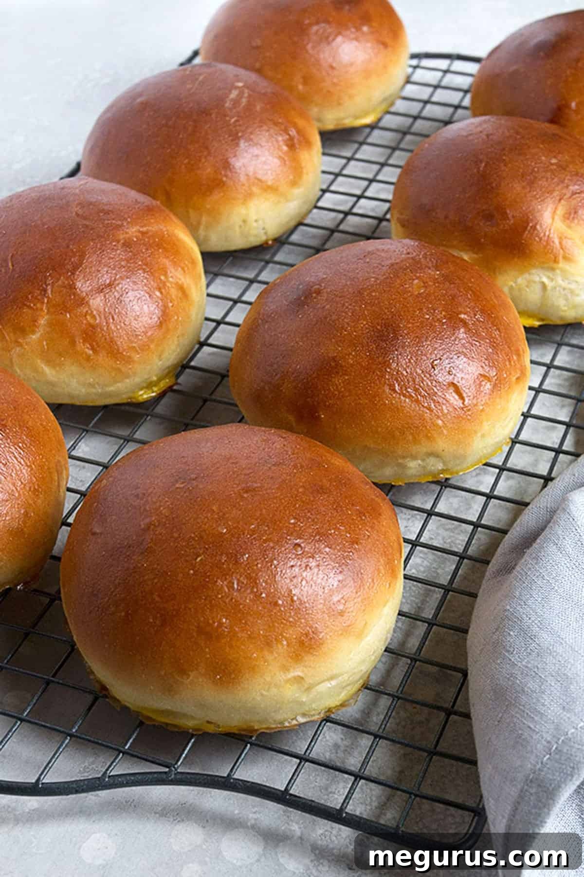 Close-up of golden brown homemade hamburger buns cooling on a rack