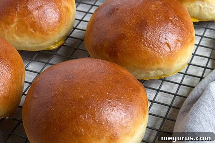 Homemade hamburger buns on cooling rack, showcasing their texture