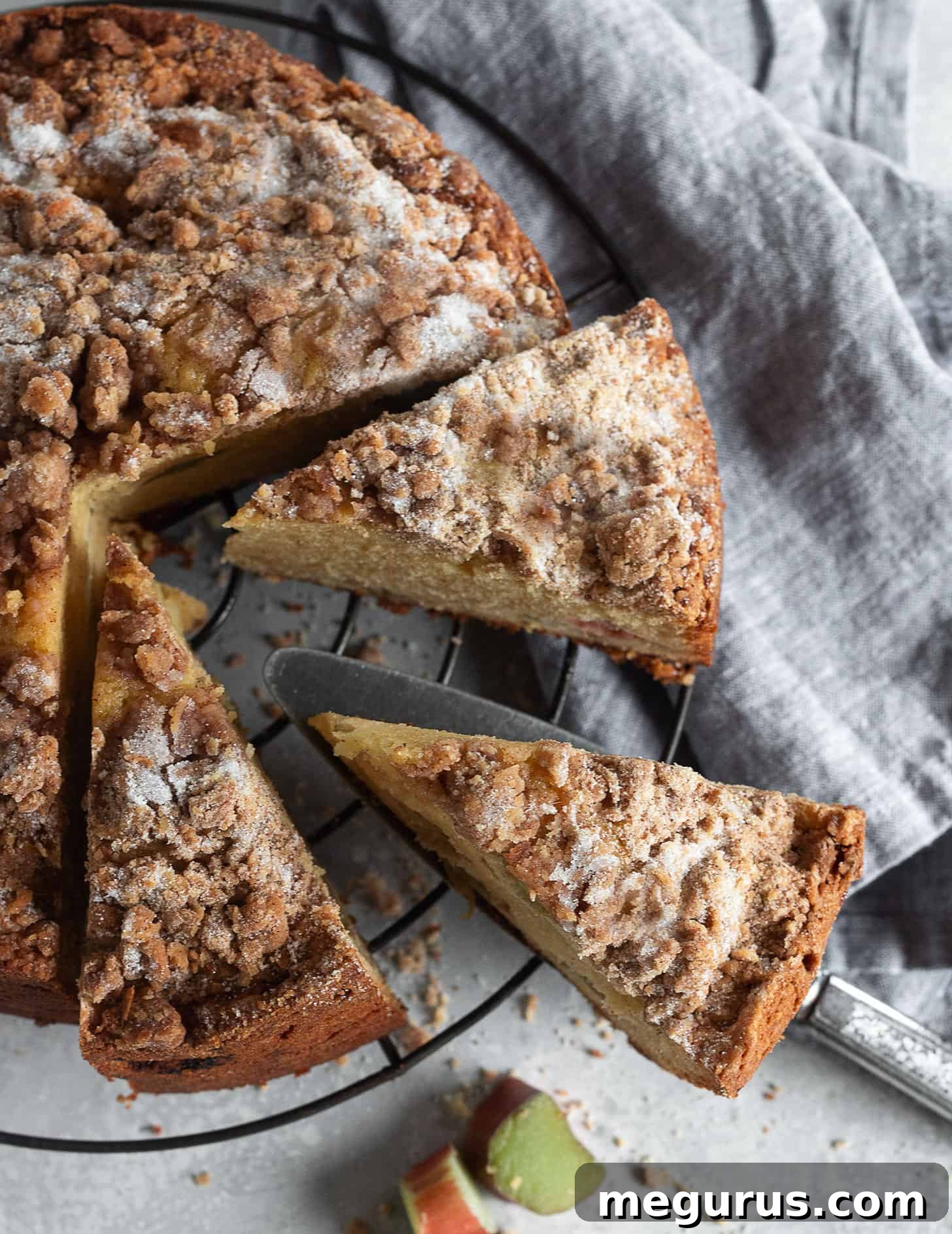 Close-up of a sliced rhubarb crumble cake, showing the rich texture and fruit distribution.