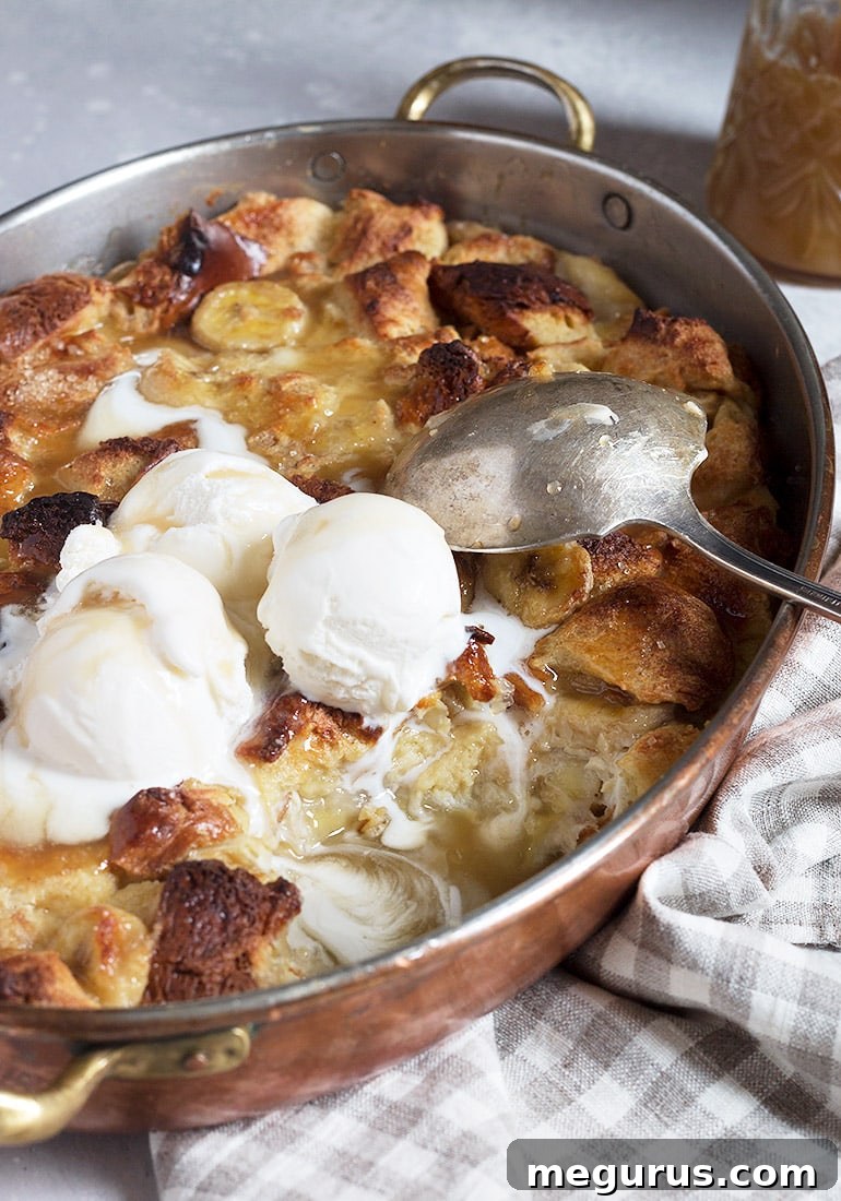 Bananas Foster Bread Pudding baking in a pan, showing golden brown crust