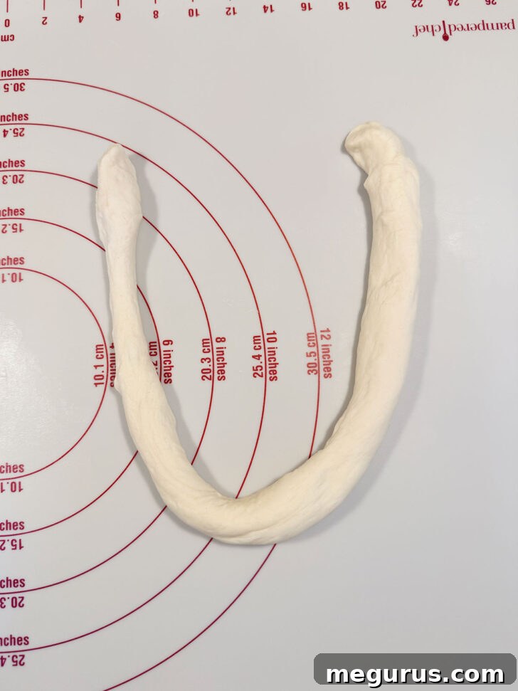 Dough rope bent into a U-shape, forming the base of the pretzel.