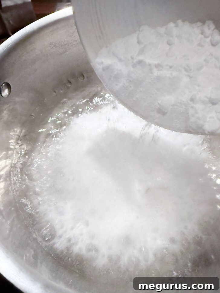 Baking soda being added to a pot of vigorously boiling water, creating a foamy reaction.