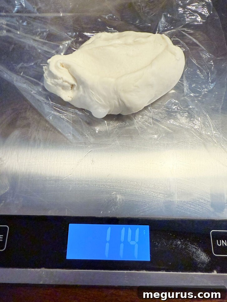 Individual dough pieces being weighed on a scale to ensure consistent pretzel sizes.