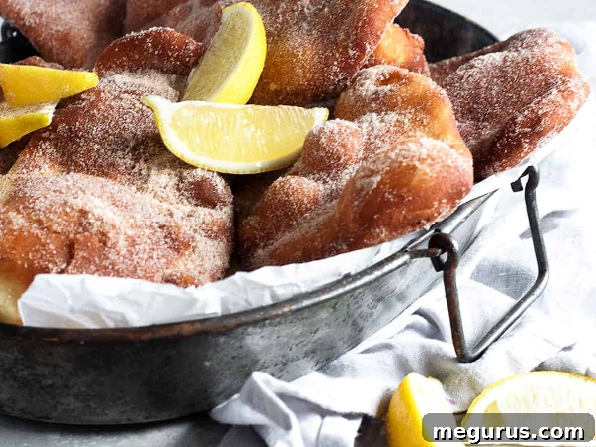 Classic Canadian Beavertails served on a platter with fresh lemon wedges, ready to be enjoyed.