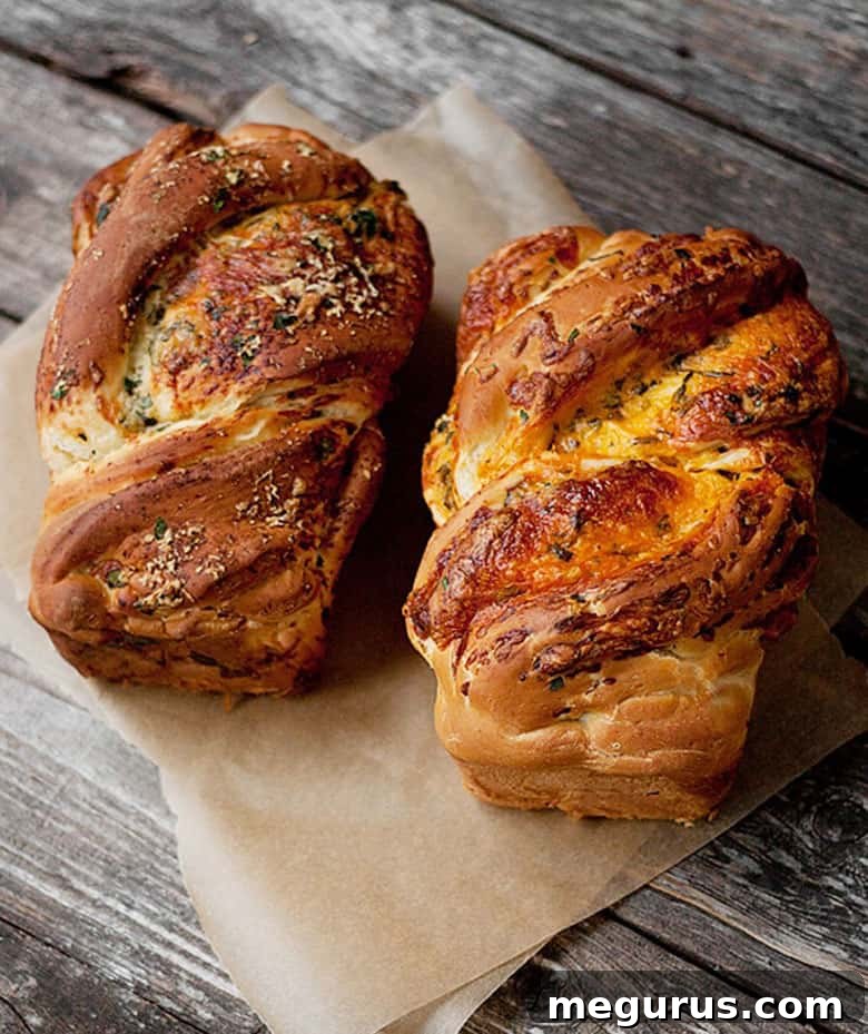 A freshly baked loaf of homemade cheese bread, cut into slices on a piece of parchment paper, showcasing its soft interior and cheesy swirls.