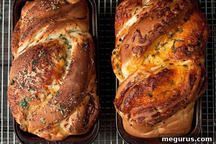 Homemade cheese bread with a golden crust and visible cheesy swirls, served in loaf pans.