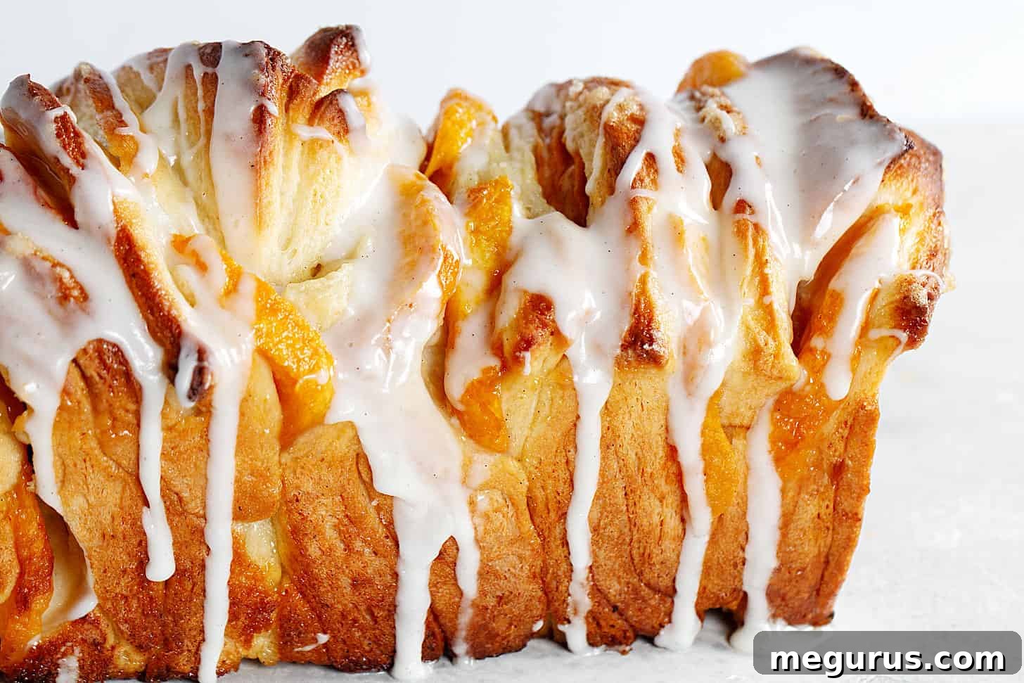 Delicious peach pull apart bread, side view, showcasing layers of bread and peaches.
