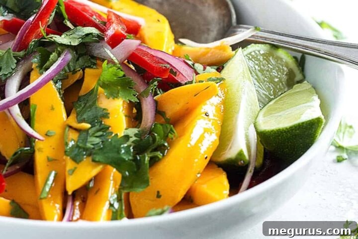 Mango salad in white bowl with spoon