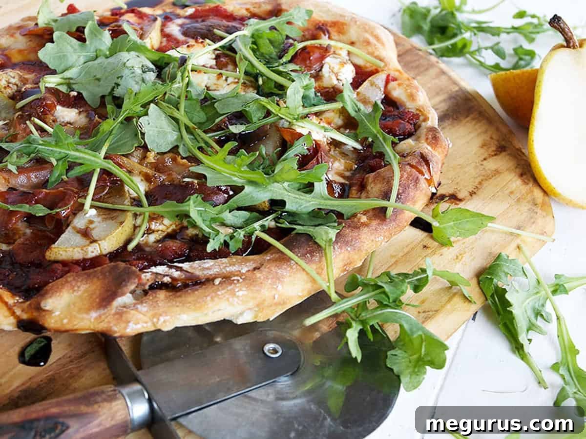 Gourmet pear prosciutto pizza on a pizza peel, ready to be served.