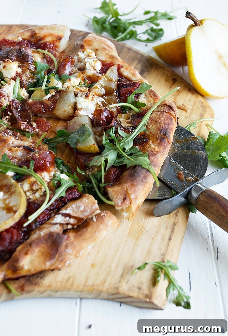 Close-up of a slice of pear prosciutto pizza on a pizza peel, showing the toppings.