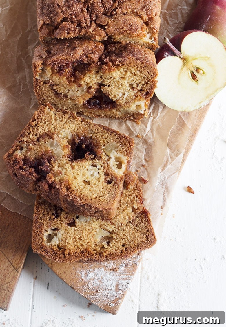 Close-up of cinnamon apple bread sliced on a cutting board, revealing texture
