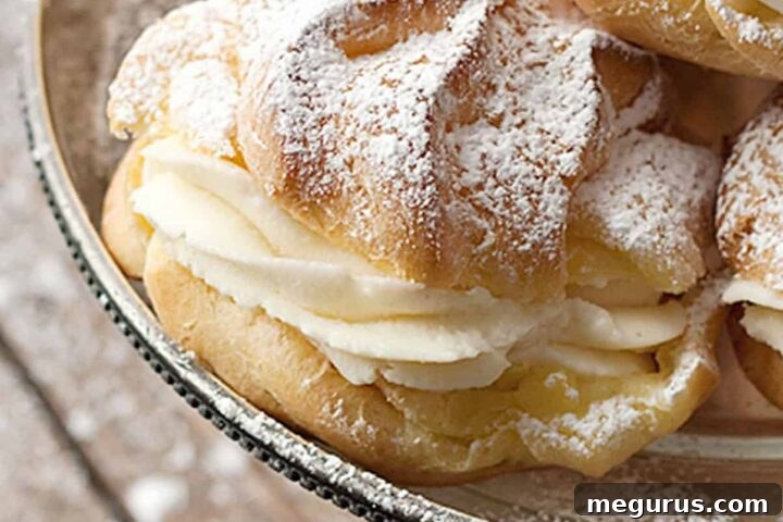 Delicate Cannoli Cream Puffs on a silver stand, ready to be enjoyed.
