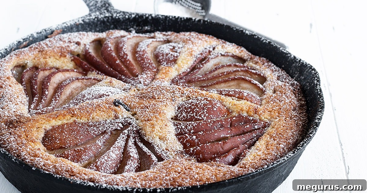 Golden-brown pear and cinnamon cake in a cast iron skillet, topped with streusel