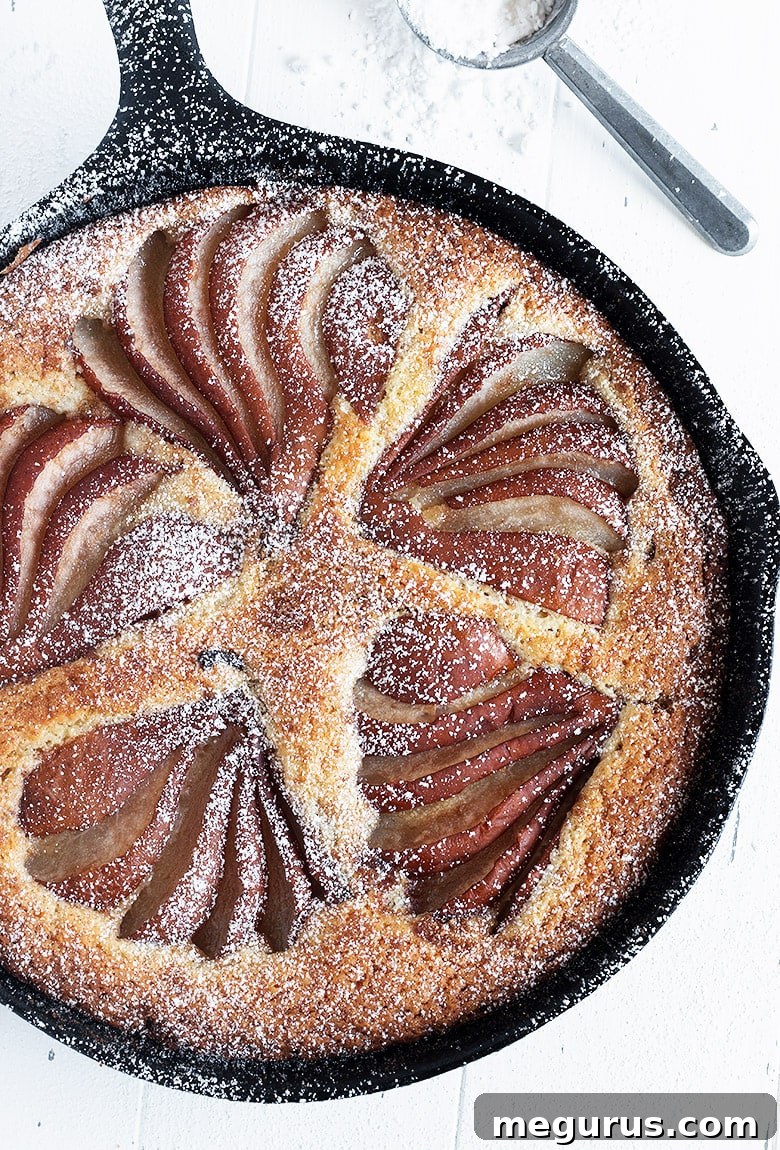 Fully baked pear and cinnamon cake, still in the cast iron skillet, ready to be served