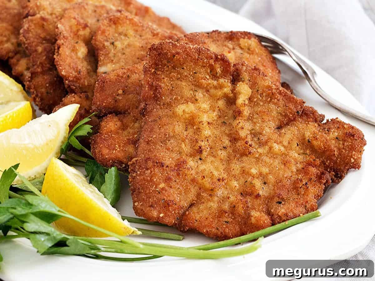 Crispy golden-brown pork schnitzel served on a plate with fresh lemon slices, ready to be enjoyed.