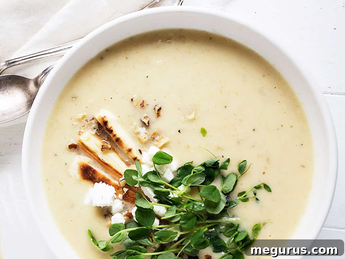 parsnip and pear soup in white bowl with garnishes on top