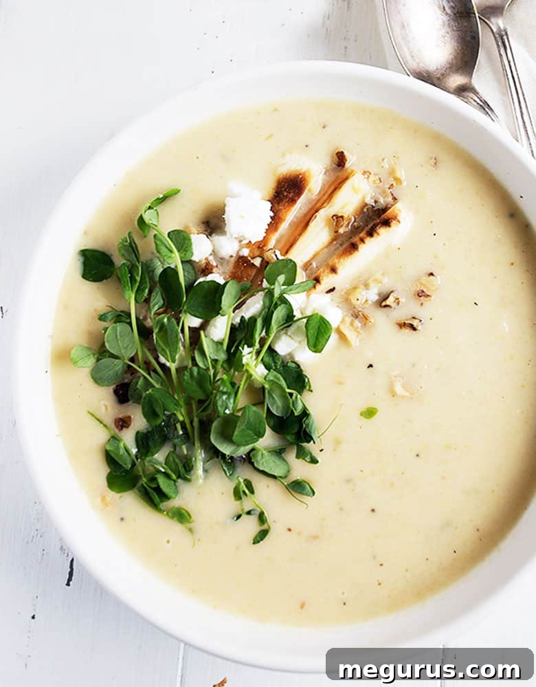 parsnip and pear soup in white bowl with garnishes on top