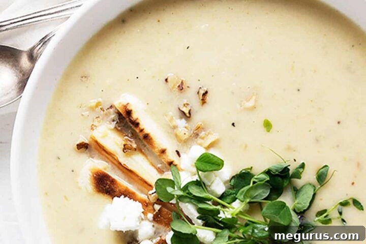 parsnip and pear soup in white bowl with garnishes on top